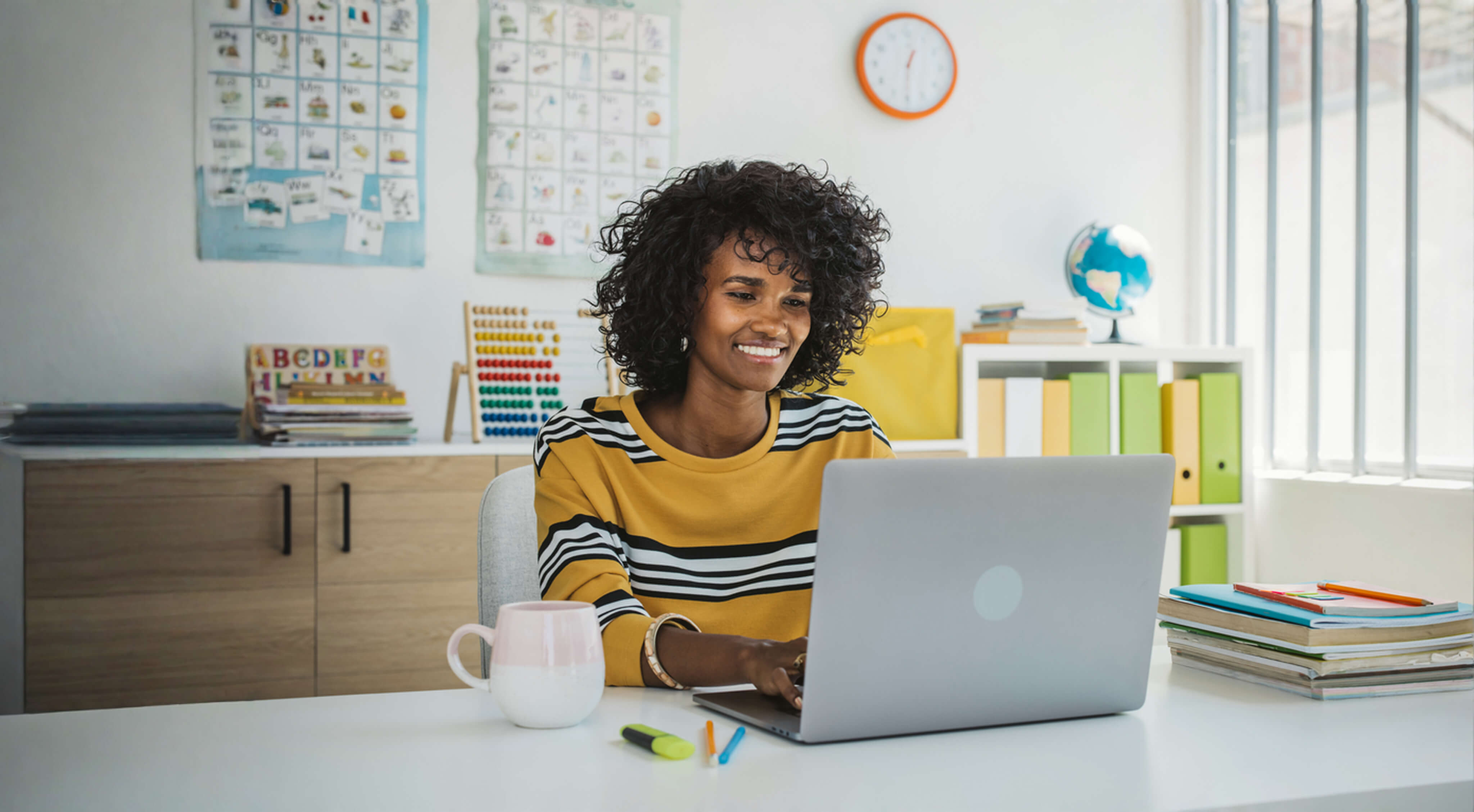 Educator sitting at computer in classroom