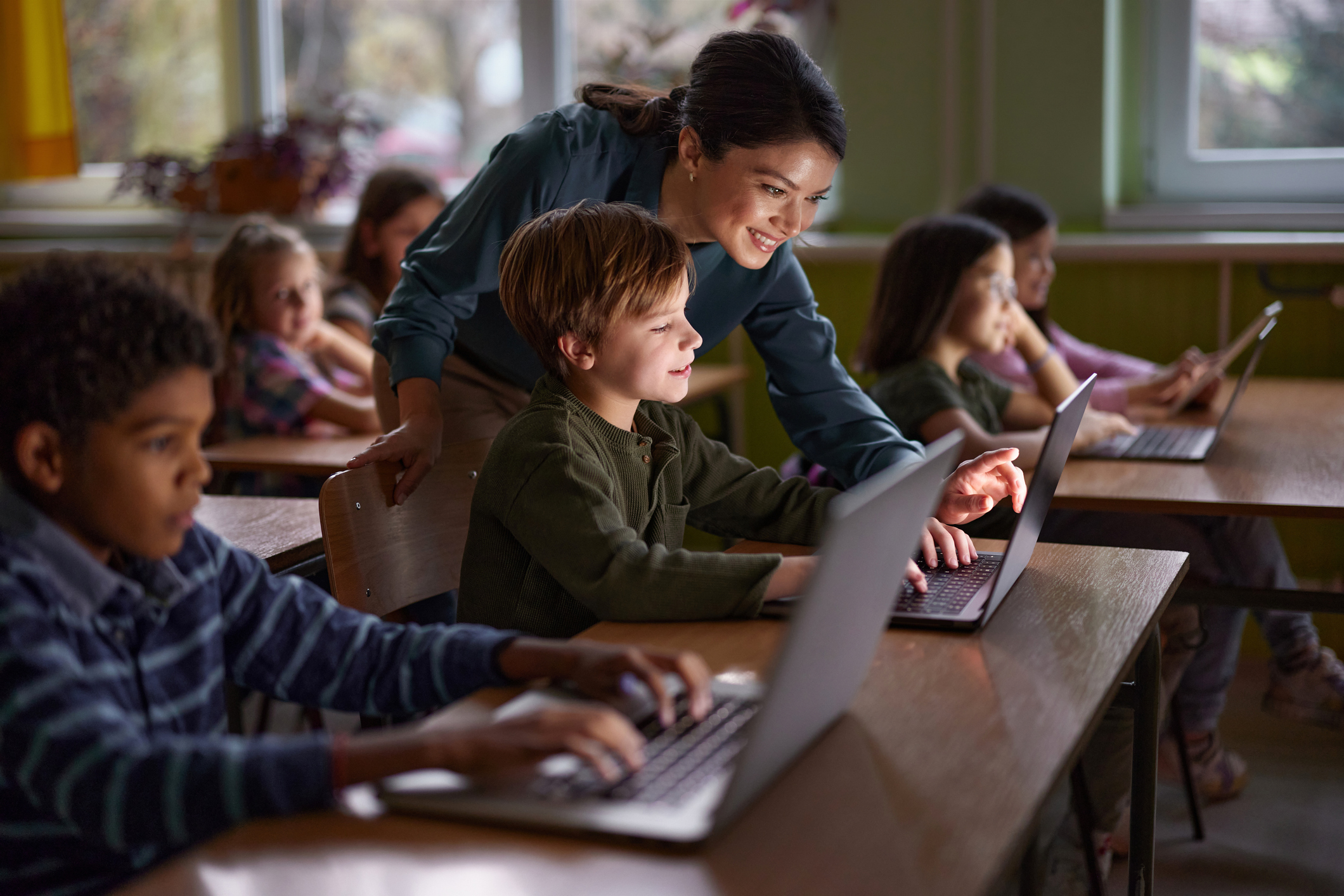 Teacher and students in classroom, working together. 