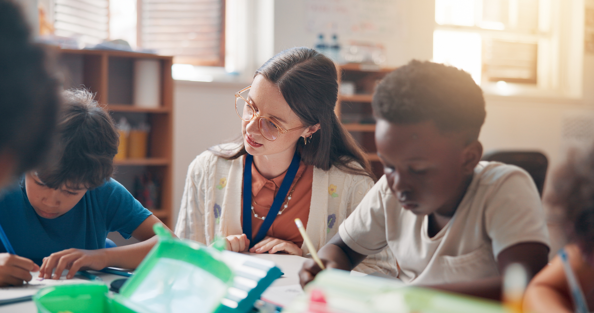 Teacher working with two students, carefully assessing. 